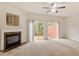 Spacious living room featuring a fireplace, sliding glass doors, and neutral carpeting at 615 Carlton Commons Ln, Cary, NC 27519