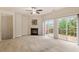 Bright living room with a fireplace, ceiling fan, large windows, and sliding glass doors to a deck at 615 Carlton Commons Ln, Cary, NC 27519