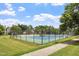 Community tennis court surrounded by mature trees and well maintained grass at 615 Carlton Commons Ln, Cary, NC 27519