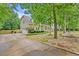 View of home with long driveway, showcasing curb appeal and mature tree landscaping at 618 Durwood Dr, Raleigh, NC 27603