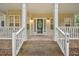 Inviting covered porch with brick accents and classic white railing, leading to the front door at 618 Durwood Dr, Raleigh, NC 27603