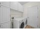 Well-equipped laundry room with white cabinetry and modern washer and dryer at 618 Durwood Dr, Raleigh, NC 27603