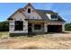 New construction featuring a brick base and a modern, open garage at 6332 River Rd, Fuquay Varina, NC 27526