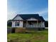 New construction home with a black roof, wrapped in white material, set on a green grassy lot at 6332 River Rd, Fuquay Varina, NC 27526