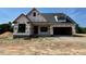 New construction featuring a brick base and a modern, open garage at 6332 River Rd, Fuquay Varina, NC 27526