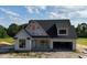 Charming new construction home with a modern white exterior, black windows and a two-car garage at 6332 River Rd, Fuquay Varina, NC 27526