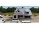 Aerial view of the new construction home, surrounded by trees and construction materials under a bright blue sky at 6332 River Rd, Fuquay Varina, NC 27526