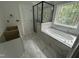 Bathroom featuring a walk-in shower, soaking tub, and modern tiling with an abundance of natural light at 701 Locust Ln, Raleigh, NC 27603