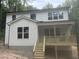 Rear exterior of the two story home with a raised back porch and new wood steps at 701 Locust Ln, Raleigh, NC 27603