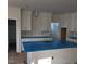 Bright kitchen featuring white cabinets, brass hardware, and a blue covered kitchen island and countertops at 701 Locust Ln, Raleigh, NC 27603