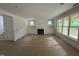 Spacious living room with a fireplace, built in cabinets, and large windows letting in lots of natural light at 701 Locust Ln, Raleigh, NC 27603