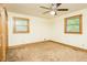 Simple bedroom featuring a ceiling fan, two windows and carpeted floor at 7030 Stockard Rd, Snow Camp, NC 27349