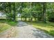 Gravel driveway leading to a charming home surrounded by mature trees and lush greenery at 7030 Stockard Rd, Snow Camp, NC 27349