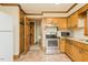 Kitchen with modern stainless appliances, wooden cabinets, and access to additional storage spaces at 7030 Stockard Rd, Snow Camp, NC 27349