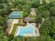 Aerial view of pool and tennis courts with mature trees surrounding it providing a quiet serene place for the community at 7409 Chesley Ln, Durham, NC 27713