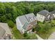 Aerial view of a single Gathering home with mature trees and lush landscaping in a quiet neighborhood at 7409 Chesley Ln, Durham, NC 27713