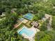 Aerial view of pool and tennis courts with mature trees surrounding it providing a quiet serene place for the community at 7409 Chesley Ln, Durham, NC 27713