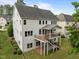Back exterior of home featuring a deck, patio, manicured lawn and landscaping at 7409 Chesley Ln, Durham, NC 27713