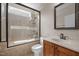 Well-lit bathroom featuring a shower with glass door and a vanity with a framed mirror at 7409 Chesley Ln, Durham, NC 27713