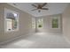 Neutral bedroom featuring three windows, carpet, and a ceiling fan at 7409 Chesley Ln, Durham, NC 27713