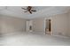 A spacious bedroom featuring a tray ceiling, ceiling fan, and carpeted floors at 7409 Chesley Ln, Durham, NC 27713