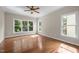 Sunlit bedroom with hardwood floors and multiple windows providing ample natural light at 7409 Chesley Ln, Durham, NC 27713