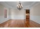 Formal dining room features gleaming hardwood floors, a decorative chandelier, and large window at 7409 Chesley Ln, Durham, NC 27713