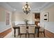Traditional dining room with elegant chandelier, wainscoting, and a view into the adjacent kitchen at 7409 Chesley Ln, Durham, NC 27713