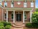 Inviting front entrance with brick steps, white columns, and a meticulously maintained garden at 7409 Chesley Ln, Durham, NC 27713