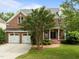 Attractive brick house with a two-car garage and landscaped front lawn with a traditional covered entryway at 7409 Chesley Ln, Durham, NC 27713
