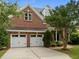 Classic brick house has a two-car garage, a manicured lawn, and a traditional covered entryway at 7409 Chesley Ln, Durham, NC 27713