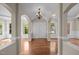 Grand foyer showcasing arched entryways, gleaming hardwood floors, a striking chandelier, and natural light at 7409 Chesley Ln, Durham, NC 27713