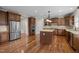 Spacious kitchen showcasing stainless appliances, wood cabinets, and a large island with granite countertops at 7409 Chesley Ln, Durham, NC 27713