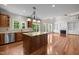 Open kitchen and living room layout featuring hardwood floors, kitchen island, and modern appliances at 7409 Chesley Ln, Durham, NC 27713