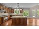 Well-lit kitchen with a center island, wood cabinets, granite countertops, and stainless steel appliances at 7409 Chesley Ln, Durham, NC 27713