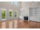 Bright open floorplan featuring hardwood floors, fireplace, built-in shelving, and access to outdoor balcony at 7409 Chesley Ln, Durham, NC 27713