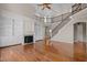 Living room boasting hardwood floors, a fireplace with built-ins, and a wrought iron staircase at 7409 Chesley Ln, Durham, NC 27713