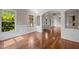 Bright living area features gleaming hardwood floors, wainscoting, arched entryway, and natural light at 7409 Chesley Ln, Durham, NC 27713
