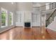 Open living room showcasing hardwood floors, fireplace with built-ins, and an elegant staircase at 7409 Chesley Ln, Durham, NC 27713