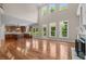 Spacious living room with hardwood floors, tall windows, and an open floor plan at 7409 Chesley Ln, Durham, NC 27713