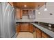 Cozy wet bar featuring wooden cabinets, granite counters, and a stainless steel refrigerator at 7409 Chesley Ln, Durham, NC 27713