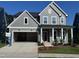 Charming two-story home with gray siding, covered porch, and attached two-car garage at 747 Bachelor Gulch Way, Apex, NC 27523