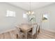 Bright dining room featuring a modern chandelier and natural light from the windows at 750 Bachelor Gulch Way, Apex, NC 27523