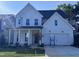 Beautiful two-story home featuring a white exterior, covered porch, and two-car garage at 750 Bachelor Gulch Way, Apex, NC 27523