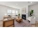 Cozy living room with a fireplace, large windows, and comfortable seating arrangement at 750 Bachelor Gulch Way, Apex, NC 27523