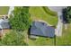 Aerial view of a well-maintained home with a dark roof and surrounded by mature trees and lush green lawn at 104 Goldleaf Ct, Angier, NC 27501
