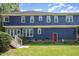Back exterior of home features a red door and steps leading to the well-maintained backyard at 104 Goldleaf Ct, Angier, NC 27501