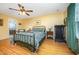 Bright bedroom featuring hardwood floors, ceiling fan, and a sitting chair at 104 Goldleaf Ct, Angier, NC 27501