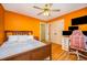 Bedroom with hardwood floors, bed, ceiling fan, and multiple monitors at 104 Goldleaf Ct, Angier, NC 27501