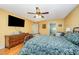 Comfortable bedroom featuring hardwood floors, ceiling fan, and mounted television at 104 Goldleaf Ct, Angier, NC 27501